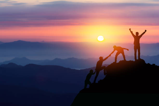 Men climbing a mountain against the backdrop of a gorgeous sunset